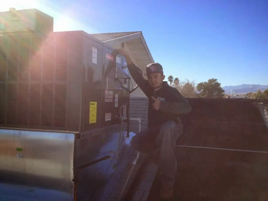 HVAC technician performing AC Tune-Up on a rooftop unit in Round Lake